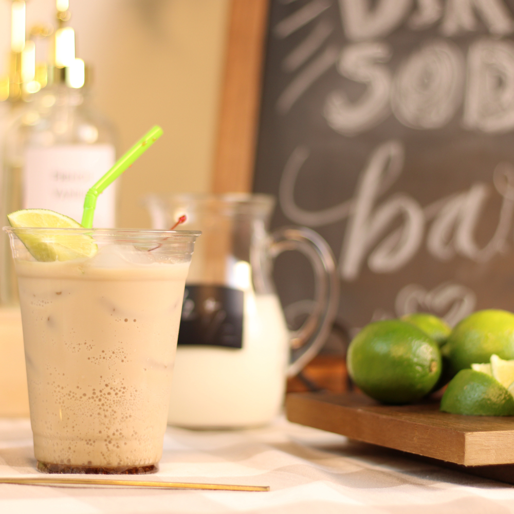 Dirty Dr Pepper with cream and flavored syrup served over ice with citrus garnish for a DIY dirty soda bar