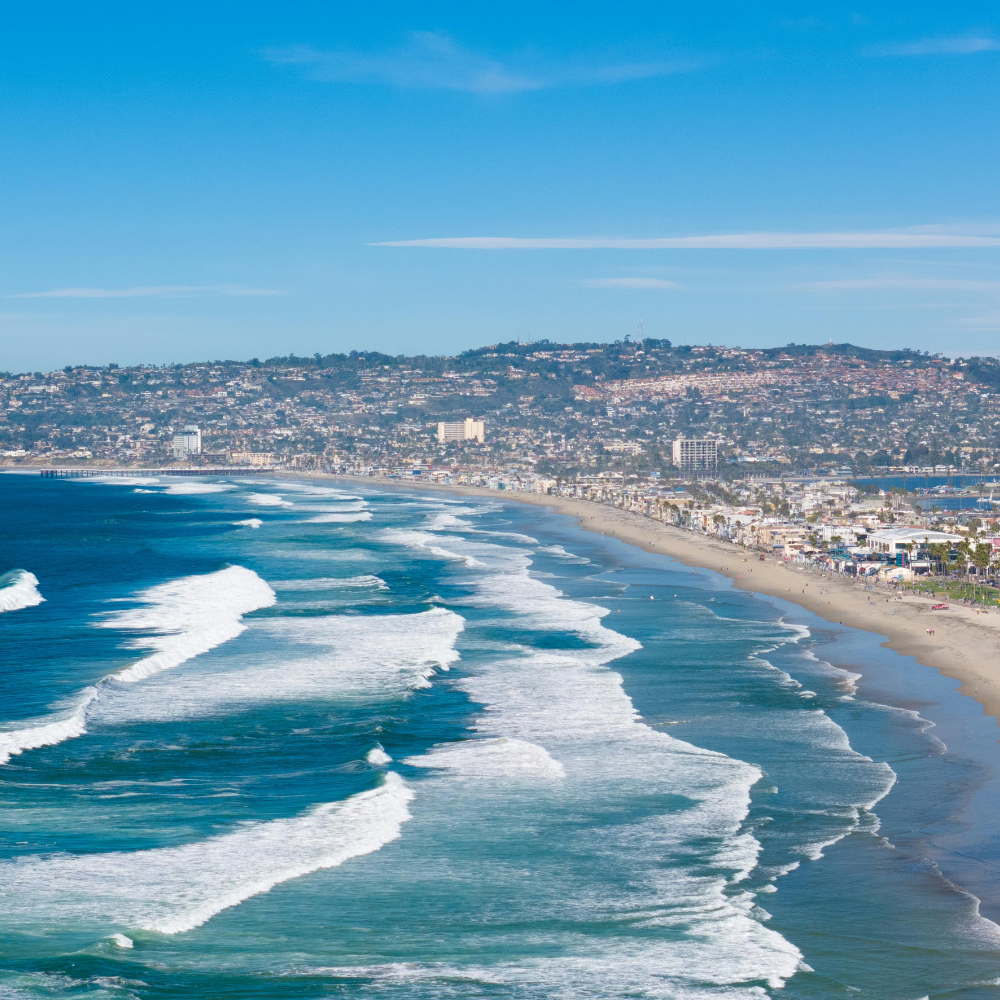 Aerial coastal view of San Diego beaches and Pacific Ocean waves on a sunny California day