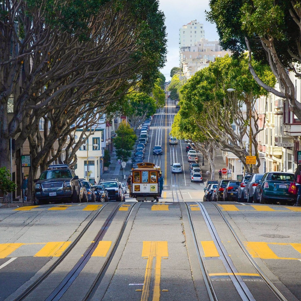 San Francisco cable car traveling up a steep city street lined with historic buildings