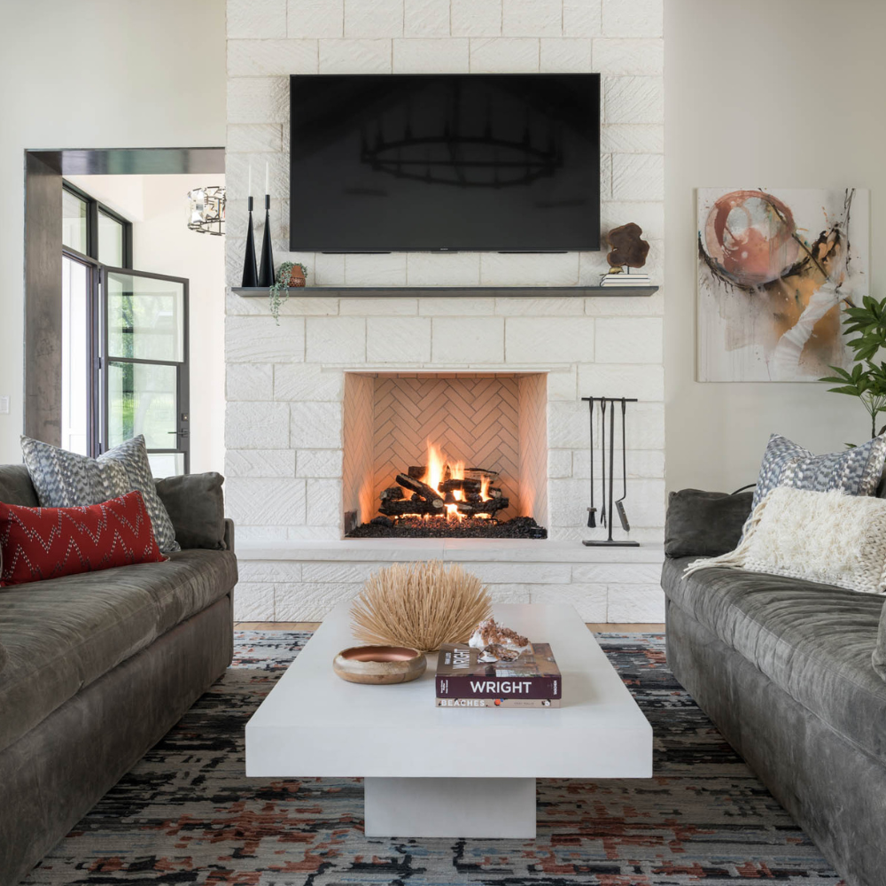 Designer looking neutral interior family room with sofas and fireplace