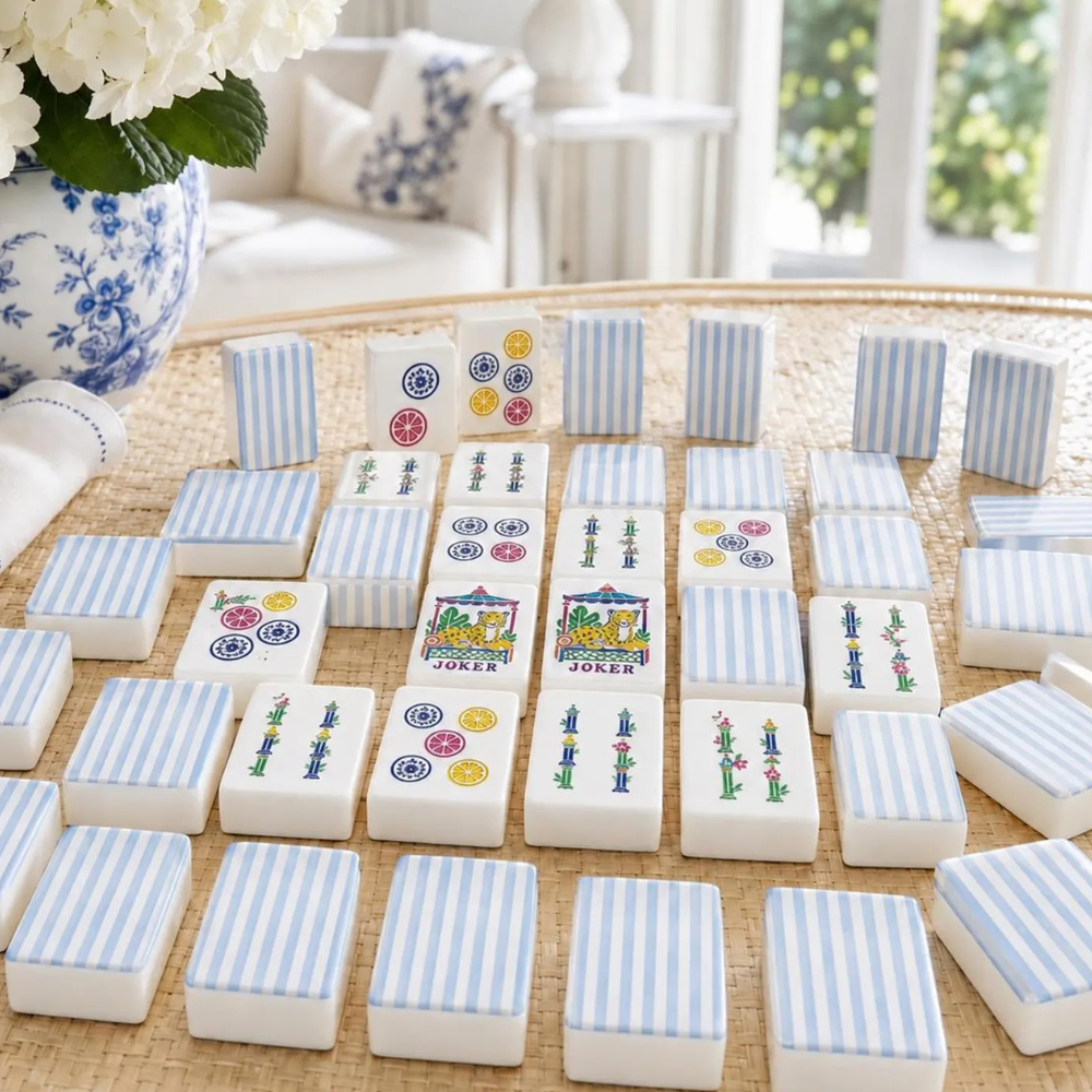 Beautiful blue and white striped American mahjong tiles styled on a rattan table with blue and white hydrangeas