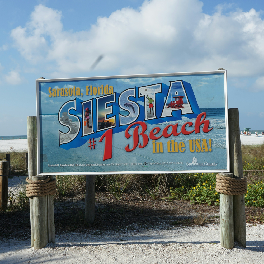 Siesta Key Beach sign in Sarasota, Florida, overlooking the white-sand beach and Gulf of Mexico
